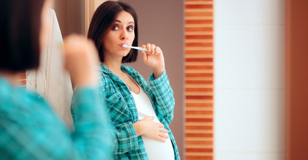 Pregnant woman brushing her teeth